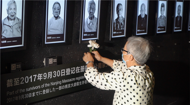 2、南京大屠殺幸存者楊翠英女兒楊懷清在熄燈儀式上為母親獻花（崔豪 攝）.jpg