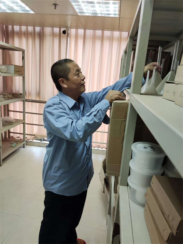 图三 彭清平在整理仓库物品.jpg