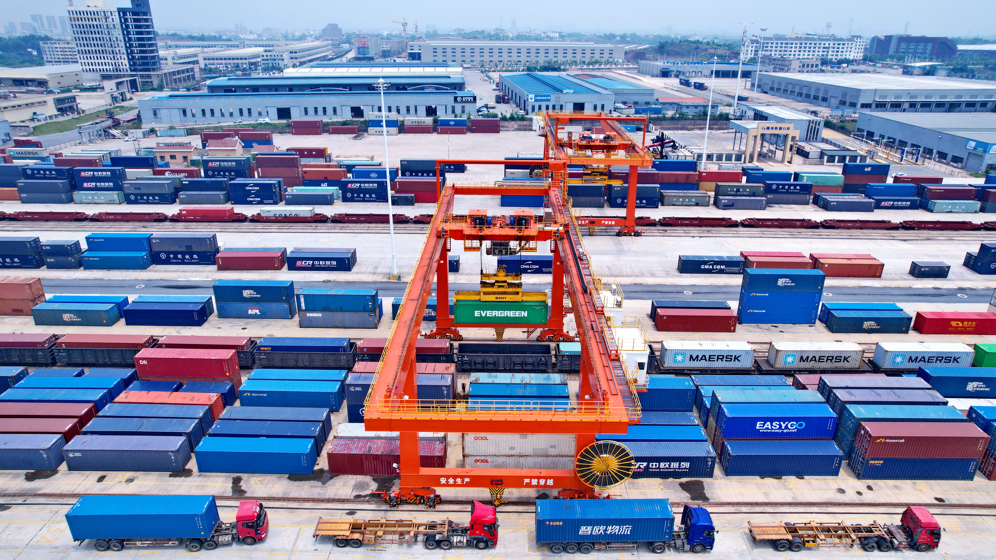 赣州国际陆港至蛇口港铁海联运班列实现双向对开，通过打造铁海联运“三同”班列精品路线，力争把南康家具打造成为具有国际影响力的世界级产业集群，助力革命老区高质量发展示范区建设。2022年5月7日，赣州国际陆港，龙门吊起重机在吊运集装箱货柜。朱海鹏 摄.jpg