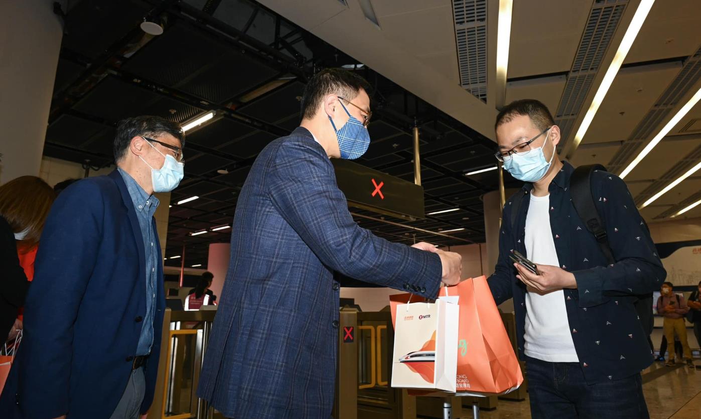 楊潤雄到西九龍高鐵站迎接乘坐首班到港列車乘客 並送上紀念品